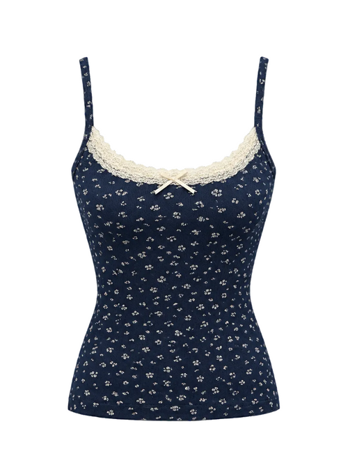 A navy blue camisole top with a small white floral print, featuring cream lace trim along the scoop neckline and a matching cream bow at the center front, displayed on a light gray background.